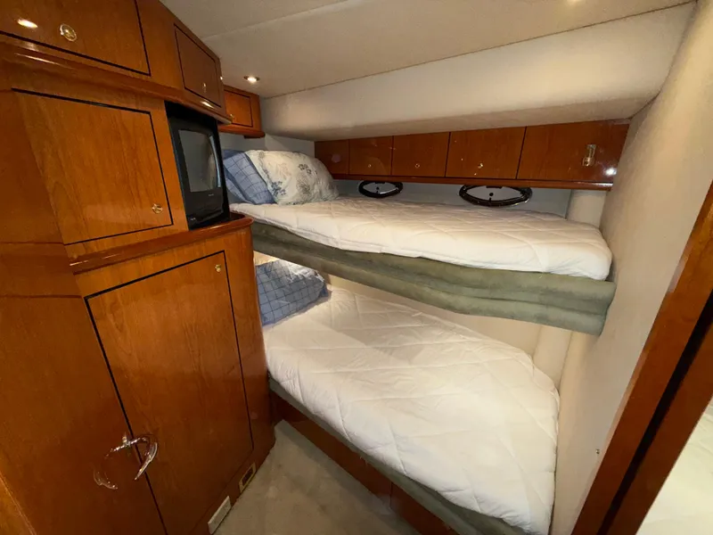 Slide: The Image of Interior cabin of 2000 Sea Ray 510 Sundancer with bunk beds and wooden cabinetry. - 33