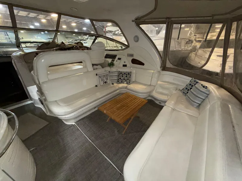 Slide: The Image of Luxurious interior of 2000 Sea Ray 510 Sundancer yacht with white seating and wooden table. - 5