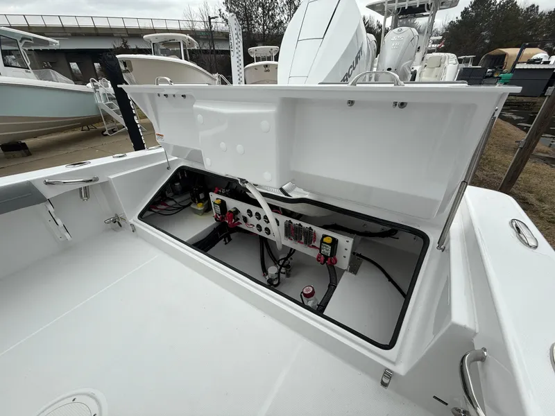 Slide: The Image of 2025 Everglades 253 Center Console boat with open storage compartment, showcasing interior wiring. - 10