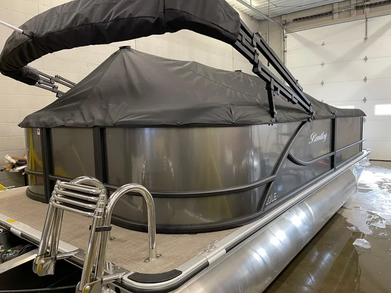 Slide: The Image of 2025 Bentley Pontoons LE 200 CW, covered, in a garage setting. - 6