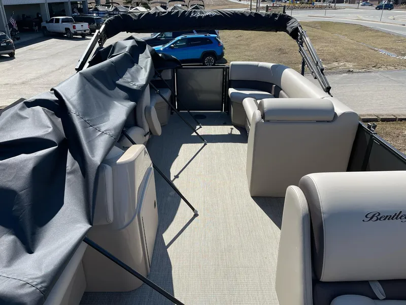 Slide: The Image of 2025 Bentley Pontoons LE 200 CW interior with beige seating and protective cover. - 9