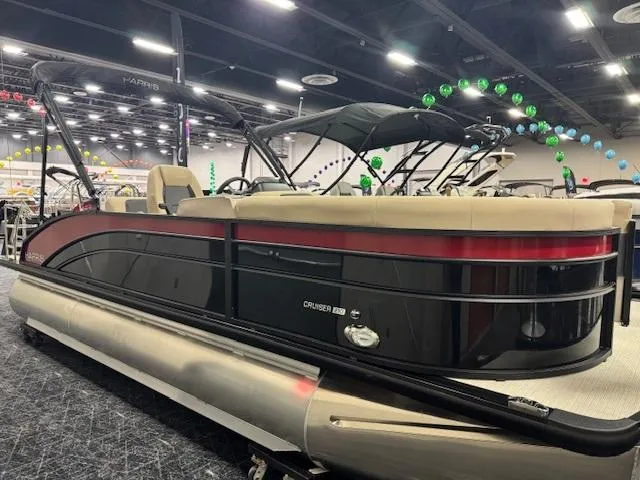 Slide: The Image of 2025 Harris Cruiser 210 pontoon boat displayed indoors with festive decorations. - 1