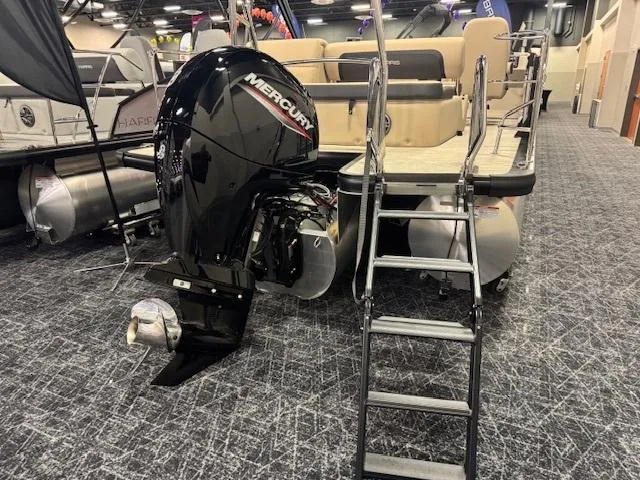 Slide: The Image of 2025 Harris Cruiser 210 pontoon boat with Mercury outboard motor displayed indoors. - 6