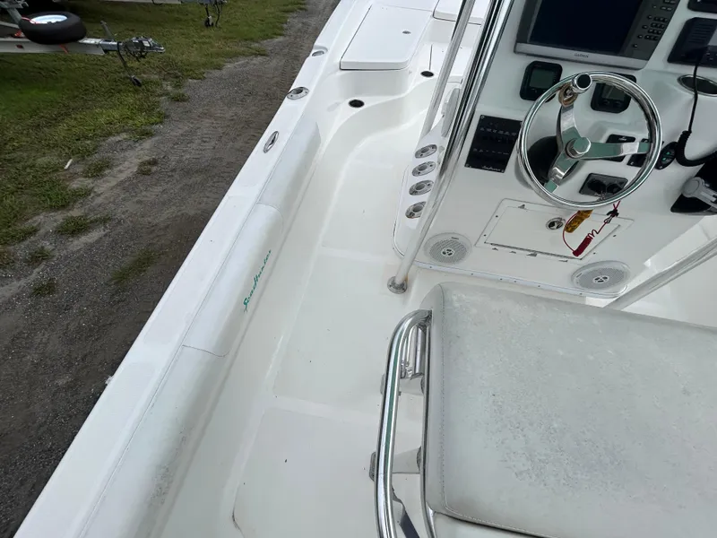 Slide: The Image of 2012 SeaHunter 24 Bay boat interior with steering console and seating area. - 11