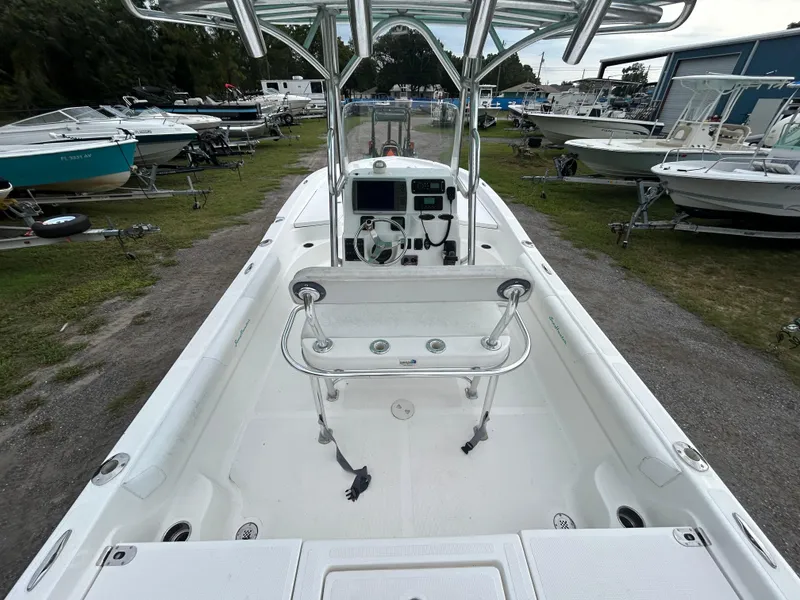 Slide: The Image of 2012 SeaHunter 24 Bay boat interior, featuring console and seating, docked among other boats. - 13
