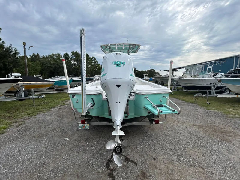 Slide: The Image of 2012 SeaHunter 24 Bay boat with outboard motor, parked on gravel lot under cloudy sky. - 3