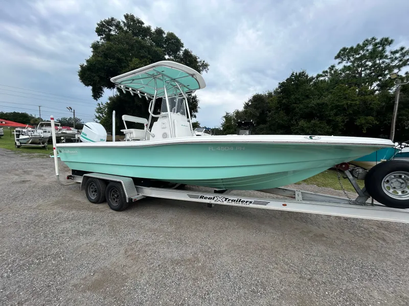 Slide: The Image of 2012 SeaHunter 24 Bay boat on trailer, light blue hull, parked outdoors. - 5
