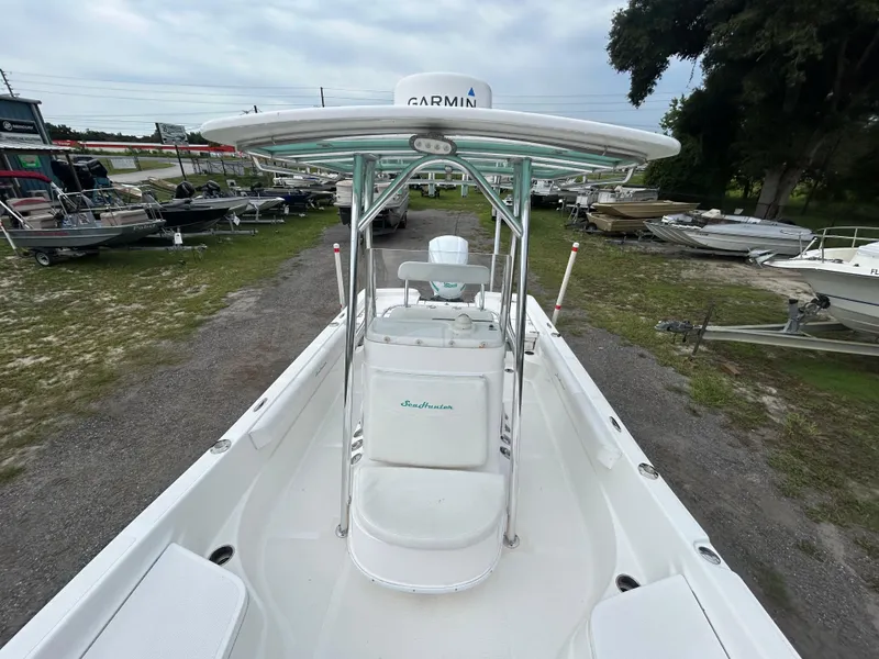 Slide: The Image of 2012 SeaHunter 24 Bay boat with Garmin equipment, parked outdoors among other boats. - 7