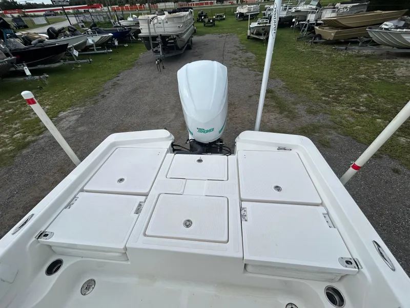 Slide: The Image of 2012 SeaHunter 24 Bay boat with outboard motor, displayed in a boatyard. - 8