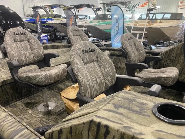 Slide: The Image of 2025 SeaArk Protege boat interior with camo seats in showroom. - 6