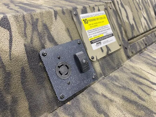 Slide: The Image of 2025 SeaArk Protege boat interior with capacity label and electrical outlet. - 8