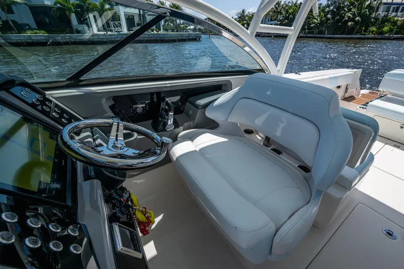 Slide: The Image of 2019 Robalo R317 Dual Console boat interior with steering wheel and comfortable seating. - 12