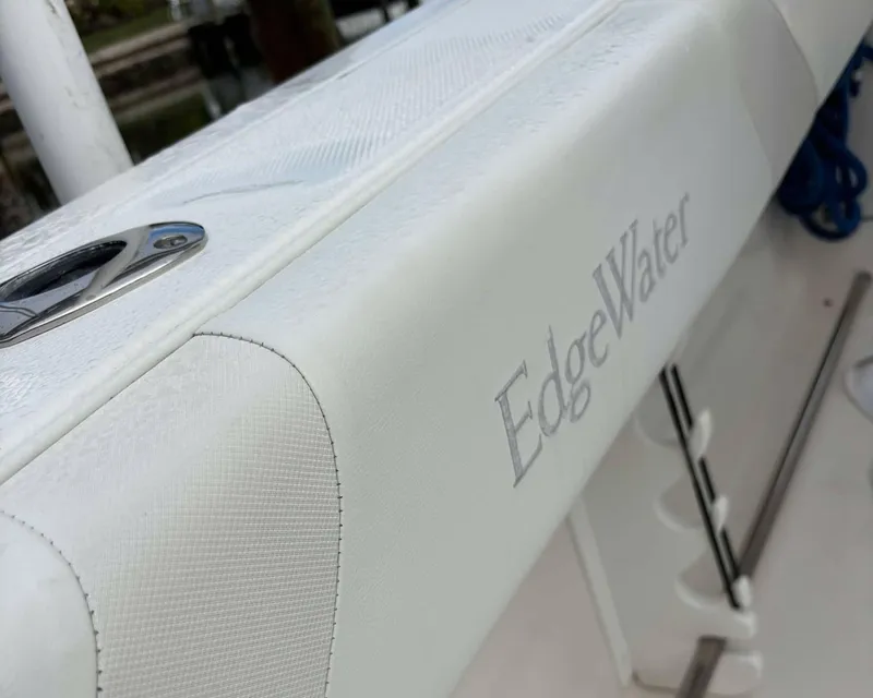 Slide: The Image of Edgewater 318CC 2012 boat detail, featuring sleek white upholstery and logo. - 17