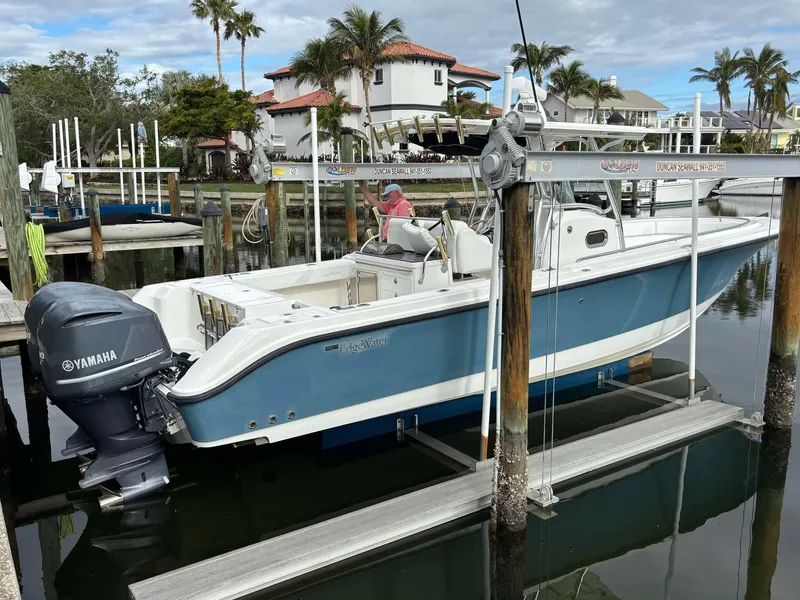 Slide: The Image of 2012 Edgewater 318CC boat with Yamaha engine docked in a marina. - 2