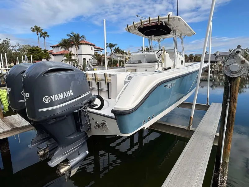 Slide: The Image of 2012 Edgewater 318CC boat with Yamaha engines docked in a marina. - 3