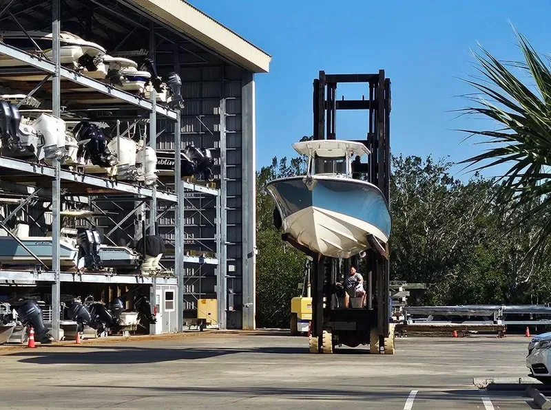 Slide: The Image of Forklift transporting 2012 Edgewater 318CC boat near storage facility. - 4