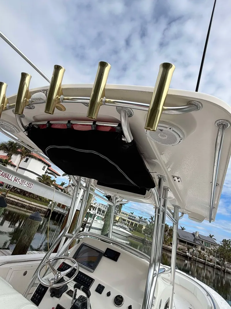 Slide: The Image of 2012 Edgewater 318CC boat with T-top and rod holders, docked at marina. - 7