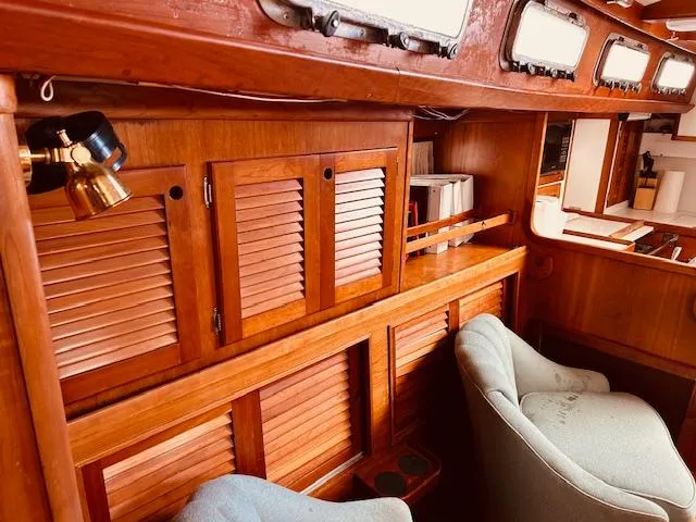 Slide: The Image of Interior of 1990 Bristol 47.7 yacht with wooden cabinets and cozy seating. - 10