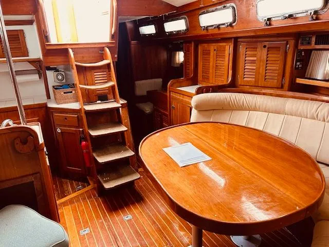Slide: The Image of 1990 Bristol 47.7 yacht interior with wooden furnishings and cozy seating area. - 3