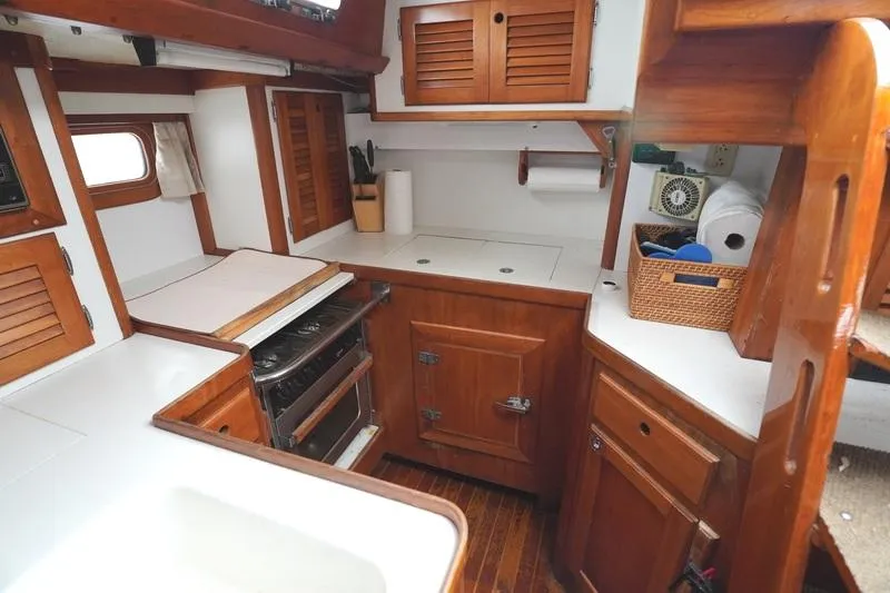 Slide: The Image of Cozy 1990 Bristol 47.7 yacht kitchen with wooden cabinets and modern appliances. - 6