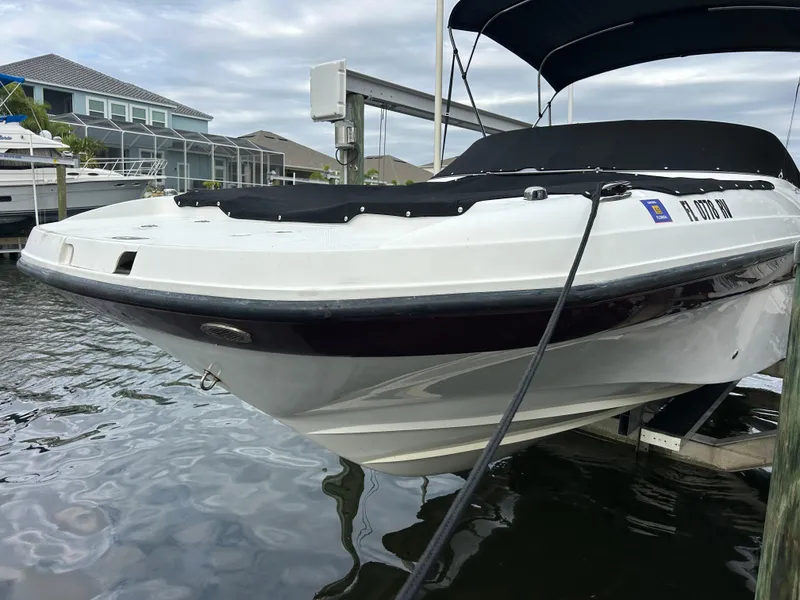 Slide: The Image of 2019 Hurricane SunDeck 2690 OB boat docked at marina, covered and ready for use. - 2