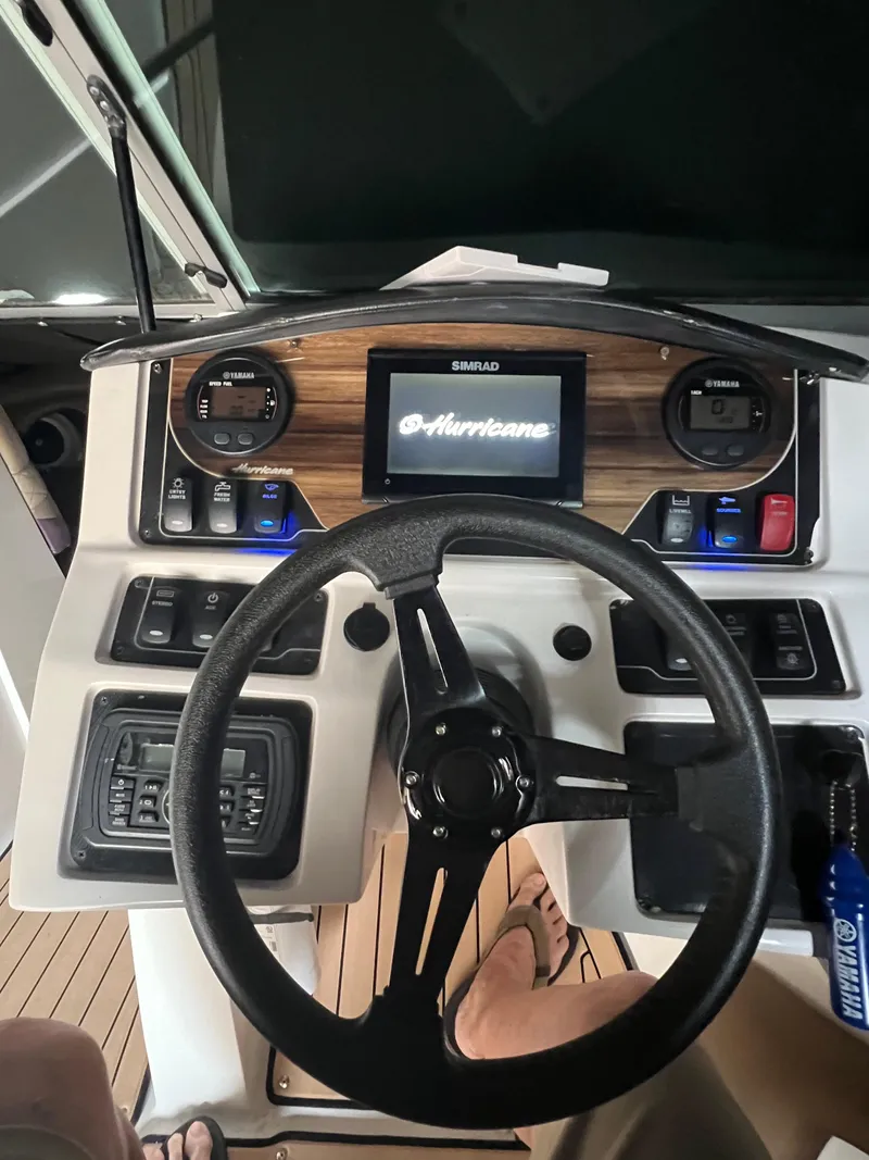 Slide: The Image of 2019 Hurricane SunDeck 2690 OB boat dashboard with steering wheel and control panel. - 29