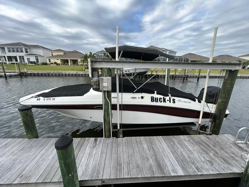 Slide: The Image of 2019 Hurricane SunDeck 2690 OB boat docked in a marina with overcast skies. - 3