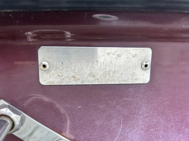 Slide: The Image of 2019 Hurricane SunDeck 2690 OB identification plate on maroon surface. - 38