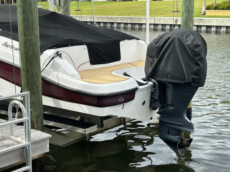 Slide: The Image of 2019 Hurricane SunDeck 2690 OB boat docked with covered outboard motor. - 5
