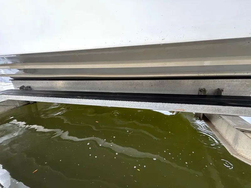 Slide: The Image of 2019 Hurricane SunDeck 2690 OB boat hull above green water. - 7