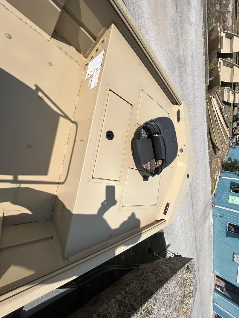 Slide: The Image of 2024 Crestliner 1860 Retriever CC Tunnel boat, beige interior, parked outdoors. - 14