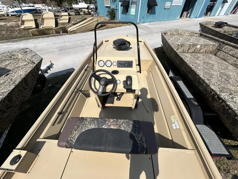 Slide: The Image of 2024 Crestliner 1860 Retriever CC Tunnel boat interior with steering console and camouflage seating. - 9