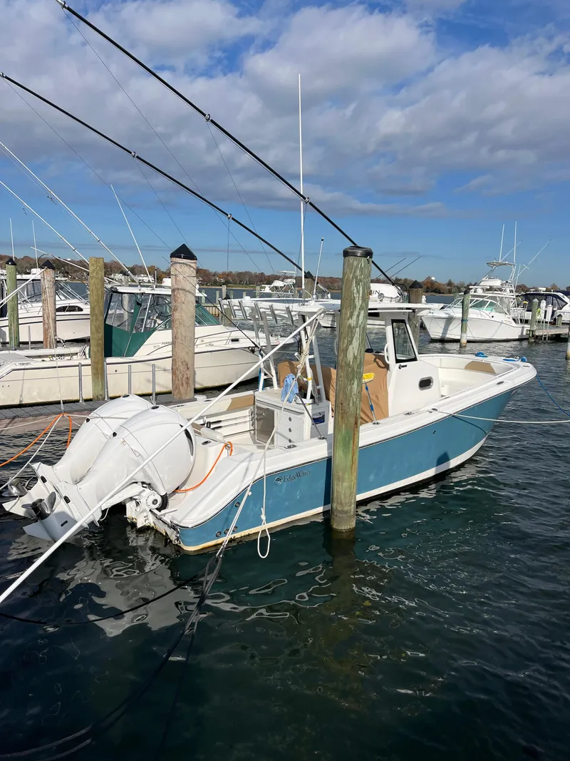 The Image of 2022 Edgewater 285CC boat docked in a marina under a partly cloudy sky. - 0