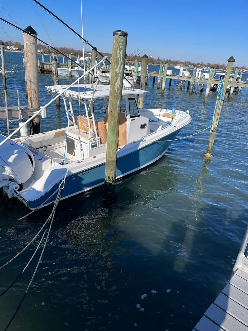 Slide: The Image of 2022 Edgewater 285CC boat docked in a marina on a sunny day. - 10
