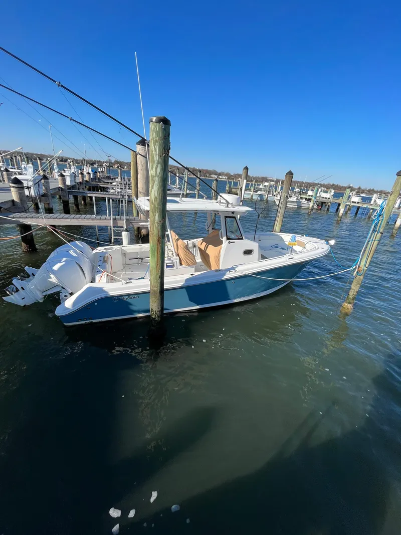 Slide: The Image of 2022 Edgewater 285CC boat docked in a marina under clear blue skies. - 11
