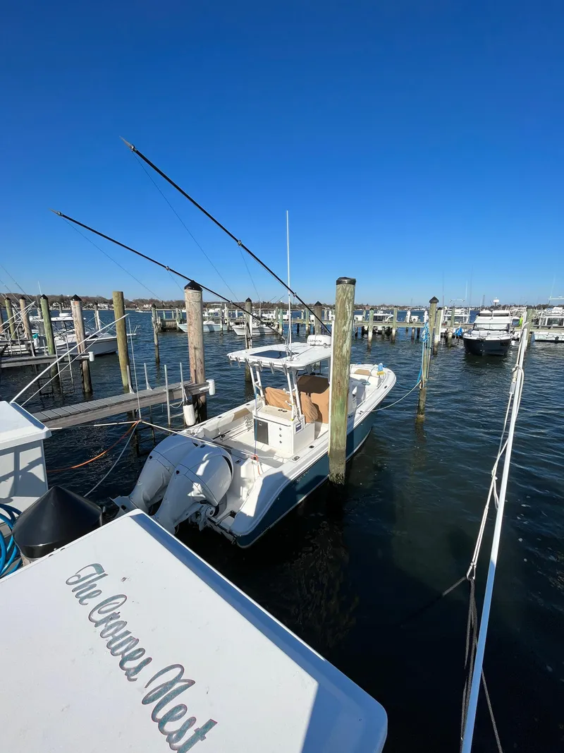 Slide: The Image of 2022 Edgewater 285CC boat docked in a marina under clear blue skies. - 13