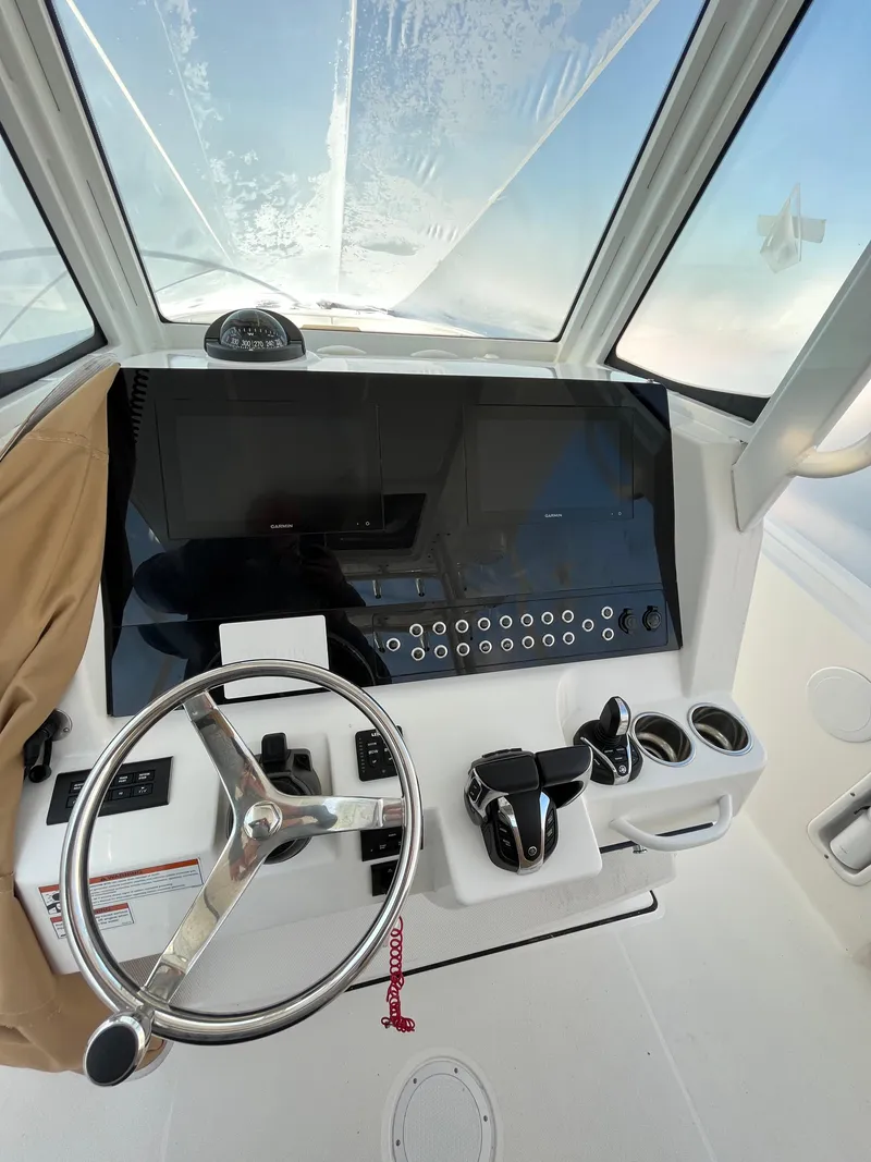 Slide: The Image of 2022 Edgewater 285CC boat dashboard with steering wheel and controls. - 19
