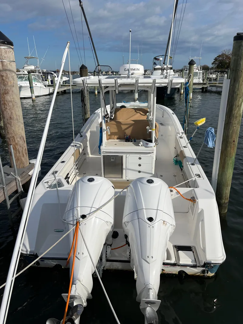 Slide: The Image of 2022 Edgewater 285CC boat docked with dual outboard engines, ready for a marine adventure. - 2