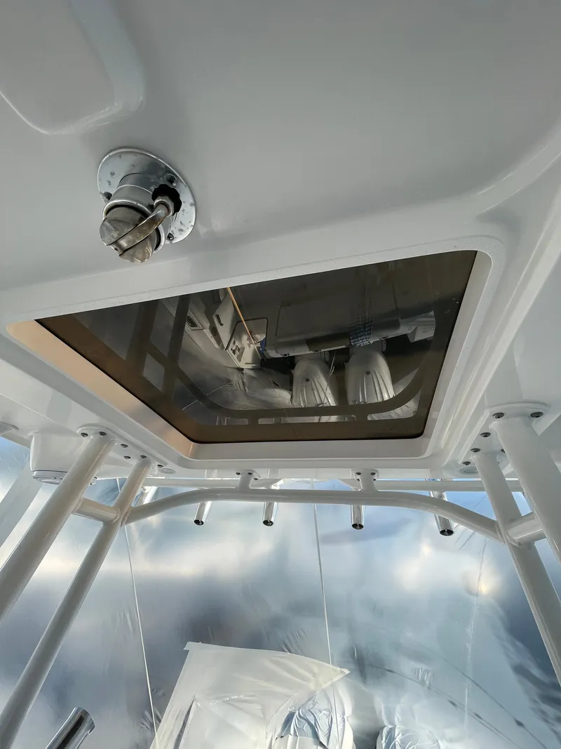 Slide: The Image of 2022 Edgewater 285CC boat interior, featuring a ceiling hatch and lighting fixtures. - 23