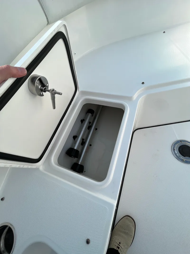 Slide: The Image of 2022 Edgewater 285CC boat storage compartment with open hatch and visible interior. - 40