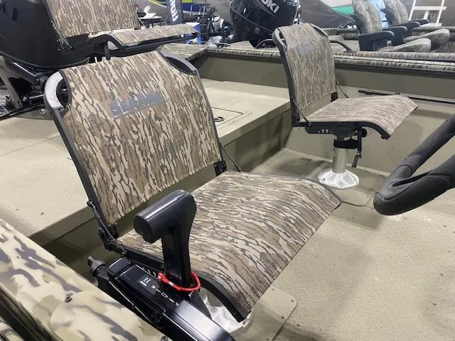 Slide: The Image of 2025 SeaArk Shadow 20 boat interior with camouflage seating and steering controls. - 8