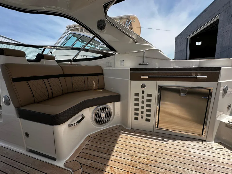 Slide: The Image of 2018 Sea Ray SLX 350 interior with seating and kitchenette, featuring wood flooring and modern design. - 1
