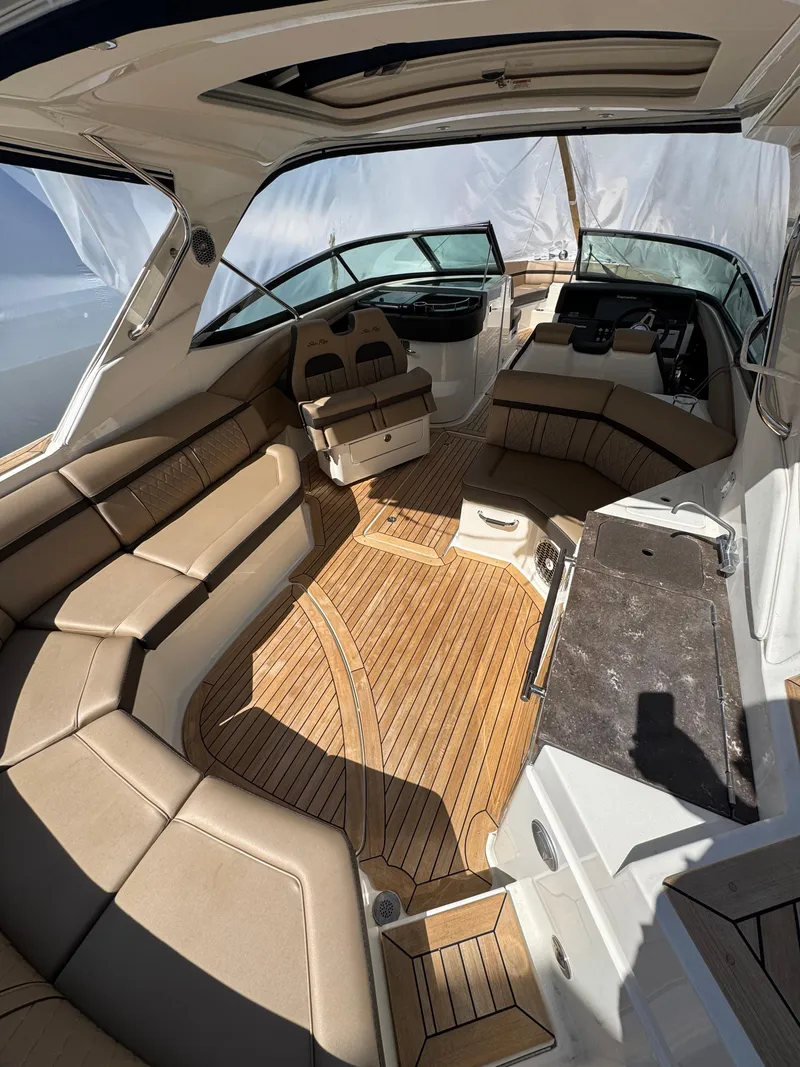 Slide: The Image of 2018 Sea Ray SLX 350 boat interior with tan seating and wood flooring. - 12