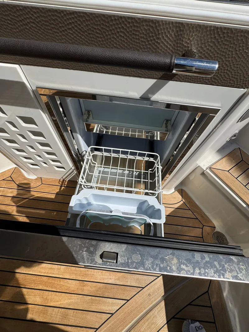 Slide: The Image of 2018 Sea Ray SLX 350 boat interior with open refrigerator on teak flooring. - 17