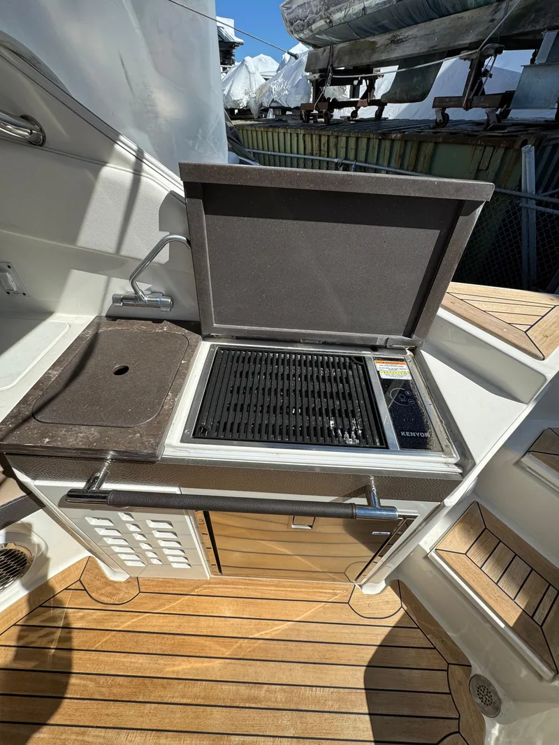 Slide: The Image of Outdoor kitchen on 2018 Sea Ray SLX 350 boat with grill and sink. - 18