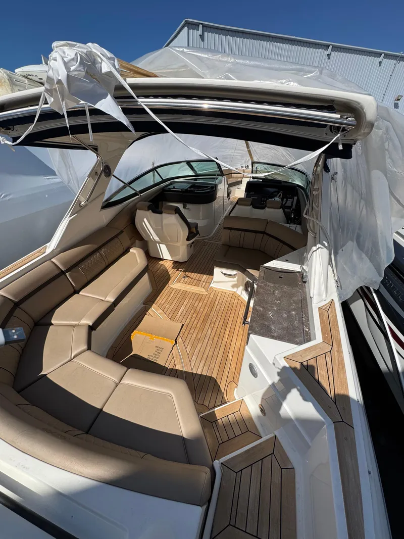 Slide: The Image of 2018 Sea Ray SLX 350 boat interior with tan seating and wood flooring. - 21