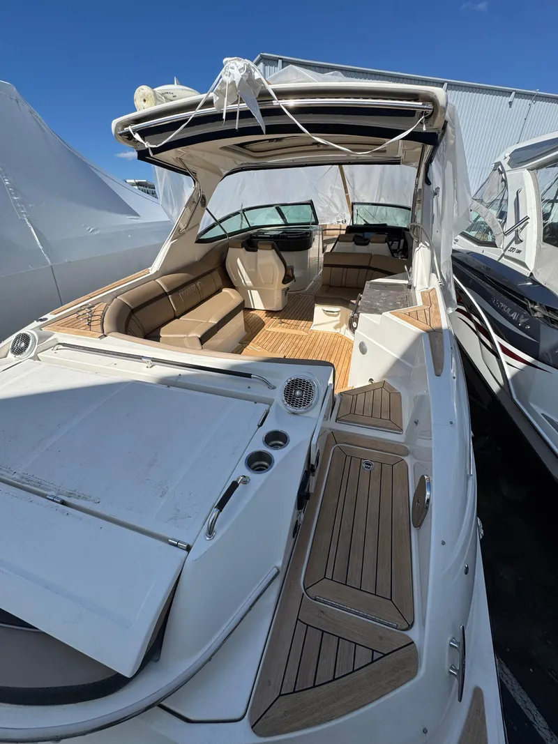 Slide: The Image of 2018 Sea Ray SLX 350 boat with spacious deck and seating, docked under clear blue sky. - 22