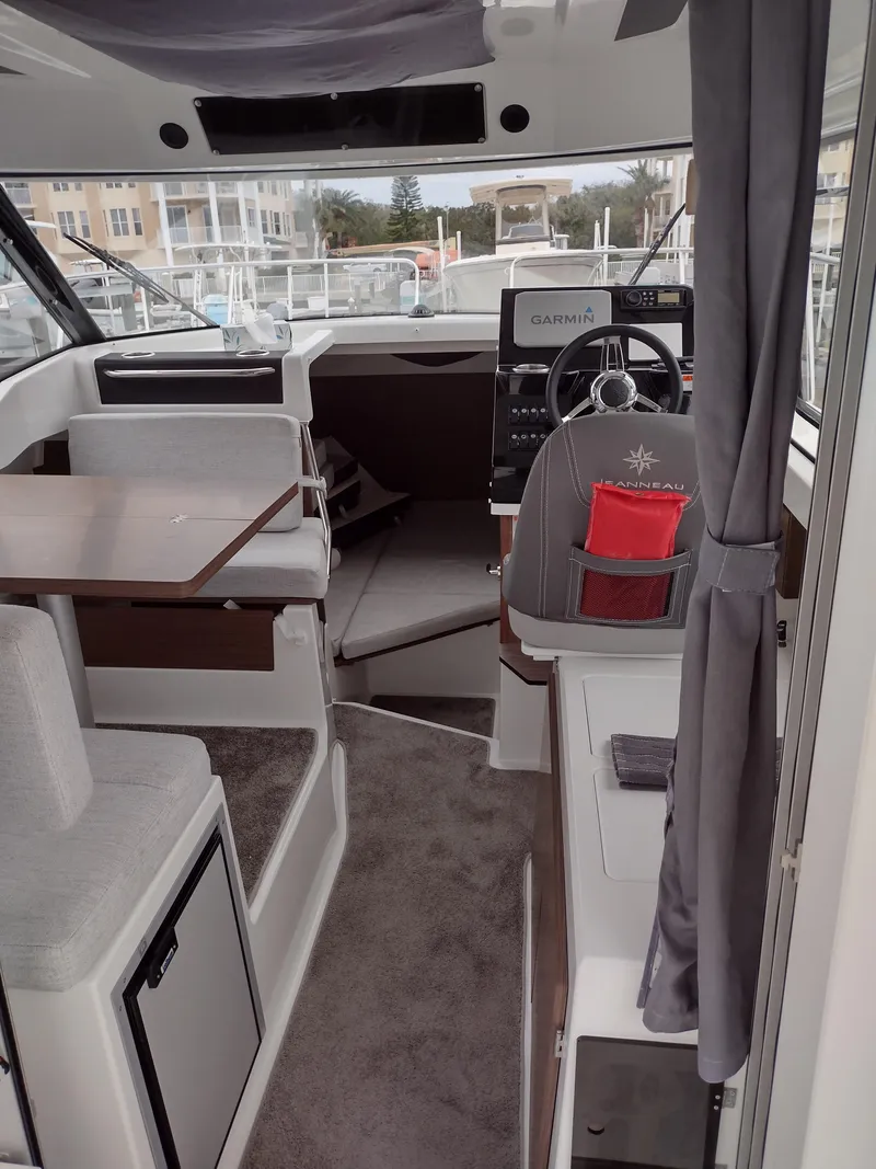 Slide: The Image of Interior of 2021 Jeanneau NC795 S2 boat with modern helm and seating area. - 8