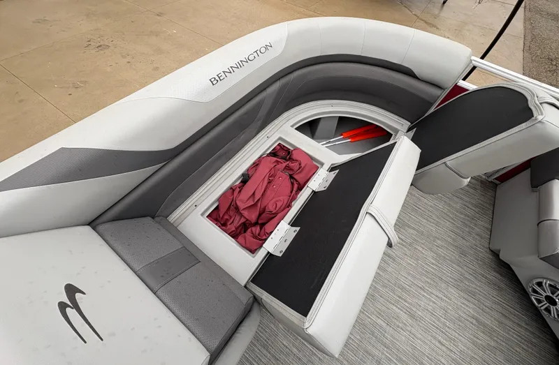 Slide: The Image of 2020 Bennington 22 SLX boat interior with storage compartment open, showcasing seating and upholstery. - 18