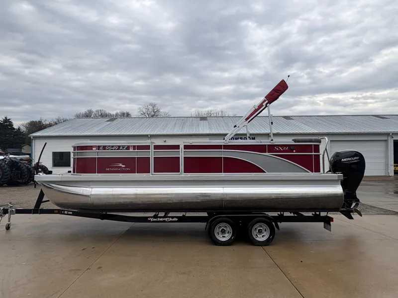 Slide: The Image of 2020 Bennington 22 SLX pontoon boat on trailer, red and silver design, overcast sky. - 4